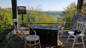 Area relax all'aperto con tavolino a baule e sedie bianche affacciata sulle colline di Passerano Marmorito, Centro meditazione Zorba Il Buddha, ritiri con tecniche di meditazione Bodhi Vipal.