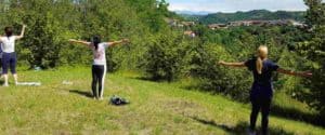 Donne di spalle su una collina con le braccia aperte durante un risveglio energetico e percorso Shinrin-yoku, tecniche di meditazione Bodhi Vipal al Centro meditazione Zorba Il Buddha.