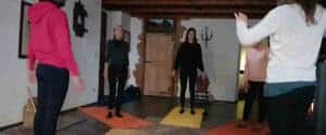 Gruppo di donne disposte in cerchio in piedi sui tappetini all'interno di una sala in legno durante un ritiro di meditazione detox, tecniche di meditazione Bodhi Vipal al Centro Zorba Il Buddha.