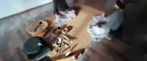 Strumenti rituali tra cui tamburo sciamanico, smudge stick e campane tibetane disposti su tappeti in sala con partecipanti seduti, tecniche di meditazione Bodhi Vipal al Centro meditazione Zorba Il Buddha.