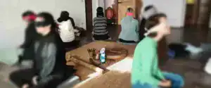 Partecipanti bendati seduti in cerchio in una sala per un rito sciamanico di purificazione, tecniche di meditazione Bodhi Vipal al Centro meditazione Zorba Il Buddha.