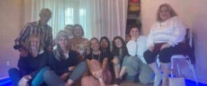 Un gruppo di persone sorridenti sedute all'interno del Centro Meditazione Zorba il Buddha durante una sessione di Costellazioni Familiari con Gabriella Borgotallo.
