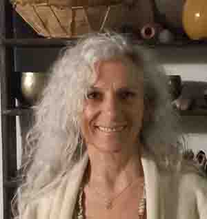 Primo piano sorridente di Maria Cordino con lunghi capelli ricci chiari durante un evento olistico di Yoga e Ayurveda al Centro meditazione Zorba Il Buddha.